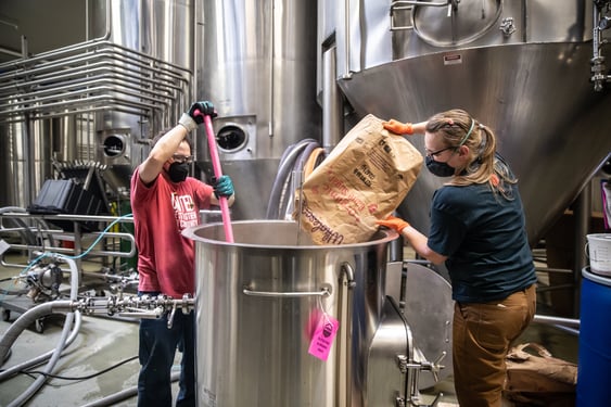 Odell Brewing employees stir up a batch of Allkind Hard Kombucha